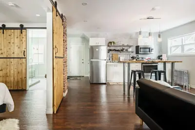 a kitchen with a refrigerator and a table with chairs at Wood-Rich Niagara Loft close to Queen Street in Niagara Falls