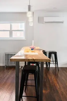 a dining room with a table and two stools at Wood-Rich Niagara Loft close to Queen Street in Niagara Falls