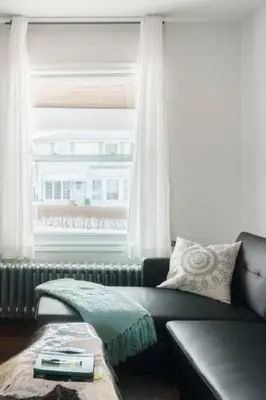 a living room with a couch and a window at Wood-Rich Niagara Loft close to Queen Street in Niagara Falls