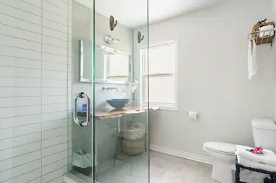 a bathroom with a glass shower stall and a toilet at Wood-Rich Niagara Loft close to Queen Street in Niagara Falls
