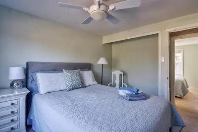 a bedroom with a blue bed with a ceiling fan at Merlot Room in Old Town in Niagara on the Lake