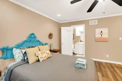 a bedroom with a large bed with a blue headboard at Family friendly Getaway Steps to the beach in Fort Erie