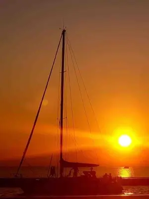 a sail boat in the water at sunset at Bobs Yer Uncle in Port Dalhousie in St. Catharines