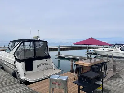 a boat on a dock with a table and an umbrella at Bobs Yer Uncle in Port Dalhousie in St. Catharines