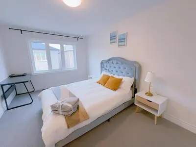 a white bedroom with a bed and a window at Vantage stay Modern 4BR townhouse pickering in Pickering