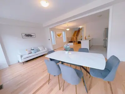 a dining room with a white table and blue chairs at Vantage stay Modern 4BR townhouse pickering in Pickering
