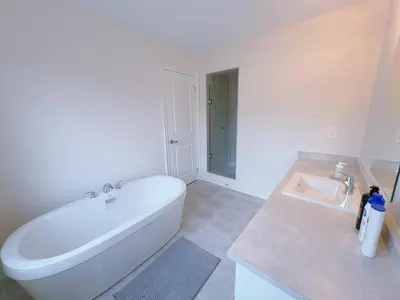 a white bathroom with a tub and a sink at Vantage stay Modern 4BR townhouse pickering in Pickering