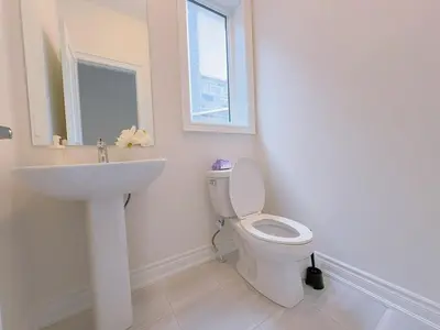 a white bathroom with a sink and a toilet at Vantage stay Modern 4BR townhouse pickering in Pickering