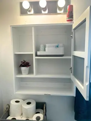a white cabinet with some rolls of toilet paper at Cozy Private Room Near Downtown Toronto in Toronto