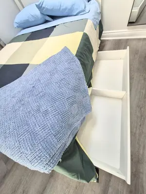 a bed with two drawers and a blanket on it at Cozy Private Room Near Downtown Toronto in Toronto