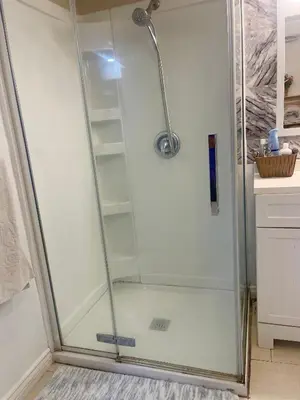 a shower with a glass door in a bathroom at Modern & Cozy Basement Suite Lower Unit - 3 rooms -1 King bed - 2 Car Parking in Pickering