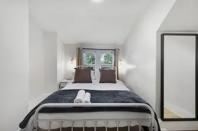 a white bedroom with a bed with a window at 2 BR 1 Bath Apt with Parking and Close to all Amenities in Oshawa
