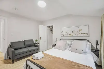 a bedroom with a large bed and a couch at 2 BR 1 Bath Apt with Parking and Close to all Amenities in Oshawa