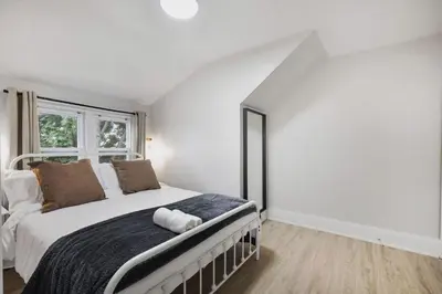a white bedroom with a large bed and a window at 2 BR 1 Bath Apt with Parking and Close to all Amenities in Oshawa