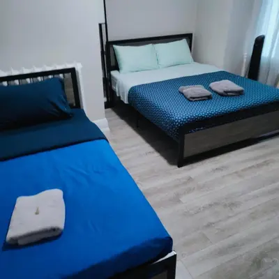 a bedroom with two beds with blue sheets and wooden floors at TORONTO BLUE JAYS- World Cup Stay in Toronto