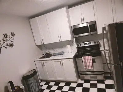 a kitchen with white cabinets and a black and white checkered floor at TORONTO BLUE JAYS- World Cup Stay in Toronto