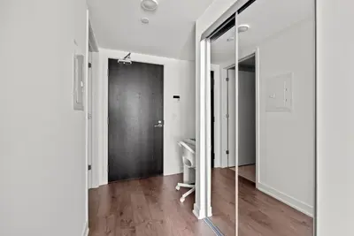 a hallway with a glass door and a mirror at Modern Studio Condo Yonge Street Downtown Toronto in Toronto