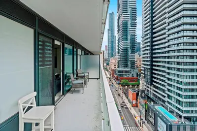an apartment balcony with chairs and a view of a city at Panoramic 2 Bedroom plus Den Condo Yonge Street Downtown Toronto in Toronto