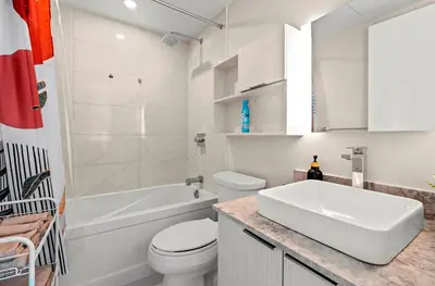 a white bathroom with a toilet and a sink at Panoramic 2 Bedroom plus Den Condo Yonge Street Downtown Toronto in Toronto