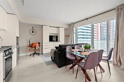 a kitchen and living room with a table and a couch at Panoramic 2 Bedroom plus Den Condo Yonge Street Downtown Toronto in Toronto