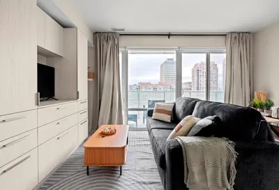 a living room with a couch and a large window at Panoramic 2 Bedroom plus Den Condo Yonge Street Downtown Toronto in Toronto