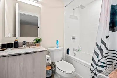 a white bathroom with a toilet and a sink at Panoramic 2 Bedroom plus Den Condo Yonge Street Downtown Toronto in Toronto