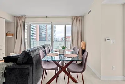 a living room with a table and a couch at Panoramic 2 Bedroom plus Den Condo Yonge Street Downtown Toronto in Toronto