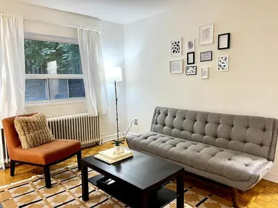 a living room with a couch and a chair at Toronto Upper Beaches Apartment in Toronto