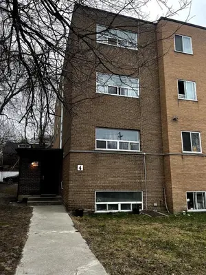 a large brick building with a door and a sidewalk at Toronto Upper Beaches Apartment in Toronto