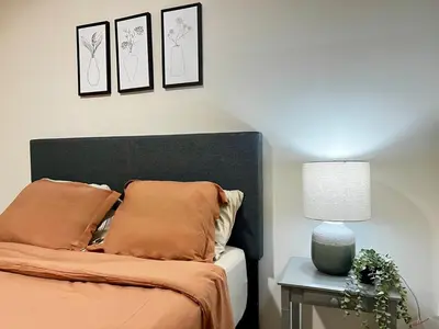 a bedroom with a bed and a table with a lamp at Toronto Upper Beaches Apartment in Toronto