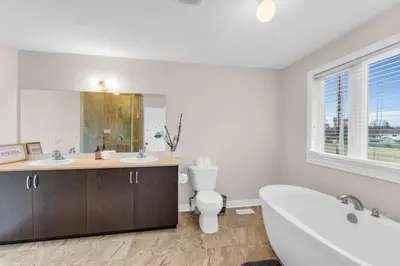 a bathroom with a tub and a toilet and a sink at Luxury Home Mins from Waterfall next to Transit in Niagara Falls