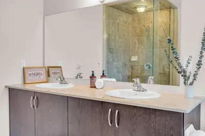 a bathroom with two sinks and a glass shower at Luxury Home Mins from Waterfall next to Transit in Niagara Falls