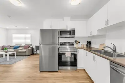 a kitchen with white cabinets and stainless steel appliances at 5 Mins to the Falls Brand New Home in Niagara Falls