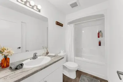 a white bathroom with a sink and a toilet at 5 Mins to the Falls Brand New Home in Niagara Falls