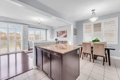 a kitchen and dining room with a table and chairs at Charming Home with Airport and Toronto Nearby in Brampton
