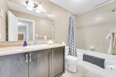 a bathroom with a sink and a toilet and a mirror at Charming Home with Airport and Toronto Nearby in Brampton