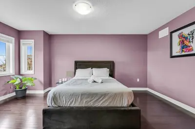 a bedroom with purple walls and a large bed at Charming Home with Airport and Toronto Nearby in Brampton