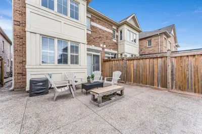 a patio with chairs and a wooden fence at Charming Home with Airport and Toronto Nearby in Brampton