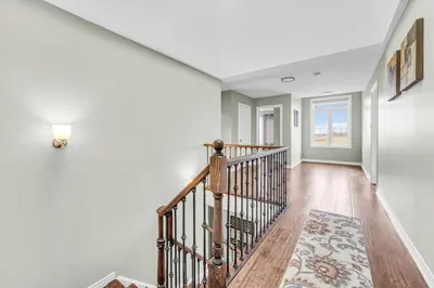 a staircase in a home with white walls at Luxury Mansion with Chefs Kitchen by Niagara Falls in Thorold