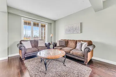 a living room with two couches and a coffee table at Luxury Mansion with Chefs Kitchen by Niagara Falls in Thorold