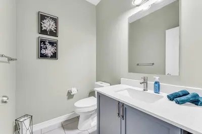a bathroom with a sink and a toilet and a mirror at Luxury Mansion with Chefs Kitchen by Niagara Falls in Thorold