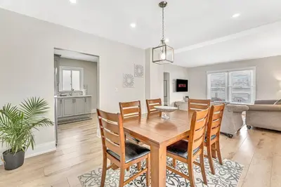 a dining room and living room with a table and chairs at Pristine Home 5 min walk to Clifton Hill in Niagara Falls