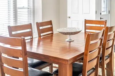a wooden table with chairs and a bowl on top at Pristine Home 5 min walk to Clifton Hill in Niagara Falls