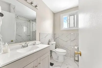 a white bathroom with a sink and a toilet at Pristine Home 5 min walk to Clifton Hill in Niagara Falls