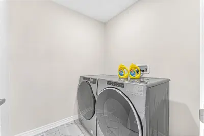 a washing machine with yellow shoes on top of it at Designer Home in Niagara Falls in Thorold