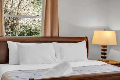 a bedroom with a bed with a window and a lamp at War of 1812 Battlefield Home by Falls in Niagara Falls