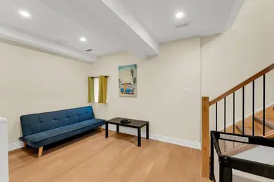 a living room with a blue couch and a table at Sunshine Villa Closest BNB to Falls Hot Tub Oasis in Niagara Falls