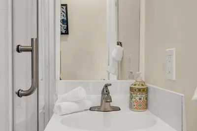 a bathroom sink with a faucet and a mirror at Sunshine Villa Closest BNB to Falls Hot Tub Oasis in Niagara Falls