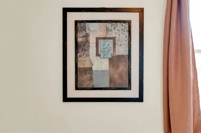 a framed picture on a wall with a curtain at Sunshine Villa Closest BNB to Falls Hot Tub Oasis in Niagara Falls