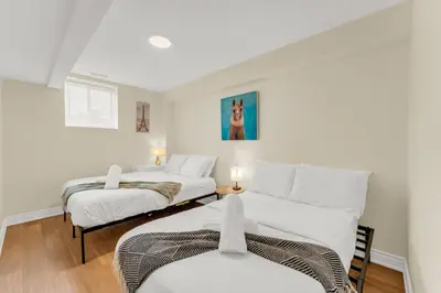 two beds in a room with white walls at Sunshine Villa Closest BNB to Falls Hot Tub Oasis in Niagara Falls